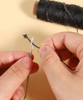 Close-up of Pro Grade Waxed Leather Thread Kit With 50M Of 150D Flat Waxed Thread and a steel needle for hand sewing.