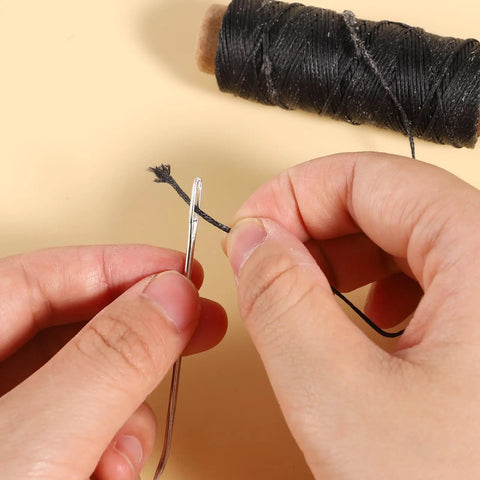 Close-up of Pro Grade Waxed Leather Thread Kit With 50M Of 150D Flat Waxed Thread and a steel needle for hand sewing.