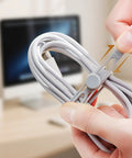Hands using Silicone Cable Ties 10 Pack Reusable Wire Wraps For Office And Home Use, Multipurpose Cable Management on charging cord.