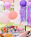 Jellyfish Paper Lanterns 6 Pack Hanging Lit Colorful Lanterns For Mermaid Unicorn Theme Classroom Decor Under The Sea Ocean Birthday Party Decorations For Undersea Parties Classroom Decor And Birthday Celebrations displayed above a birthday table setting with cake and balloons.