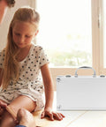 Built Tough Aluminum Alloy Work Crate With Cushion Grip Bail And Quick Release Cover For Grease Monkey Multi Layer Tool Sorting Or On The Road Health Supply Tote next to a girl getting a bandage.
