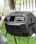 Man using 42 Gallon Black Outdoor Garden Compost Tumbler Bin With Dual Chambers Rotating for continuous composting in yard