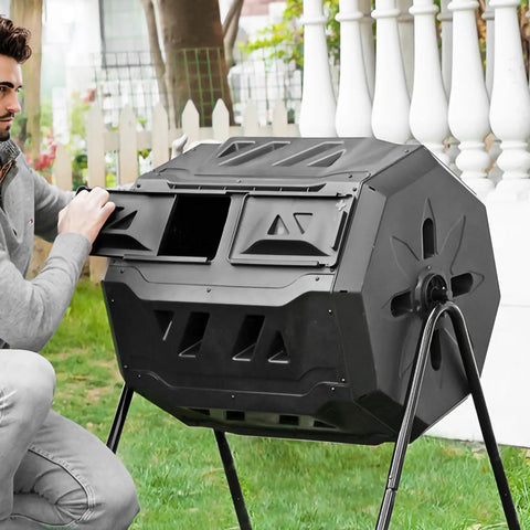 Man using 42 Gallon Black Outdoor Garden Compost Tumbler Bin With Dual Chambers Rotating for continuous composting in yard