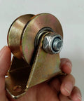 Close-up of yellow zinc-plated steel V-groove rigid caster wheel with mounting bracket and bolt