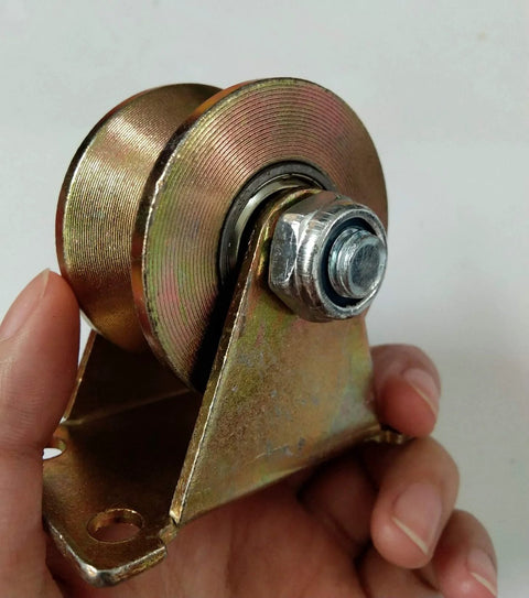 Close-up of yellow zinc-plated steel V-groove rigid caster wheel with mounting bracket and bolt