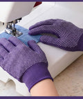 Close-up of two pairs of quilting gloves with PVC anti slip dots in purple, used for free motion sewing on a machine.