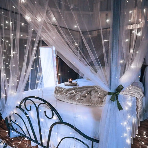 Battery Operated Curtain Lights 300 LEDs 9.8ft By 9.8ft Fairy String Lights With Remote And Timer draped over bed canopy