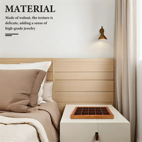 Premium Walnut Wood Jewelry Tray With 15 Grid Compartments, displayed on a bedside table beside bed pillows.