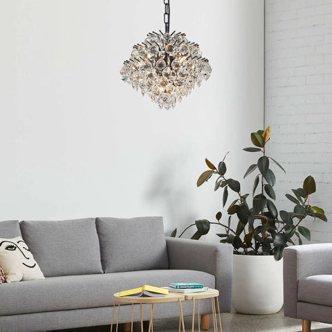 Chrome Modern Pendant Chandelier With Crystal Raindrop Lighting over living room couch and plant, 4 G9 bulbs, adjustable chain