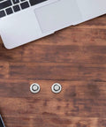 Two screws on a desk next to a laptop, part of a Ten Piece Laptop Hard Drive Screws Kit M3 Miniature Computer PC Case Screws Black Replacement Set