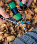 Person using Permanent Tire Repair Kit For Cars Motorcycles Off Road Vehicles Trailers SUVs Pickups ATVs UTVs And Scooters Easy To Use No Fuss Quick Fix With Dry Vulcanized Patches on a tire outdoors