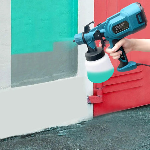 Person using Powerful 800W HVLP Paint Sprayer Kit With Three Copper Nozzle Kits to paint a wall red and green outdoors.