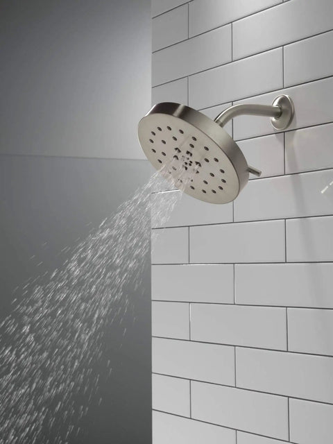 H2Okinetic 4-Setting UltraSoak Shower Head in Stainless Steel with rainlike spray on tiled wall, focusing on water sculpting tech