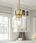 2 Pack 7 Inch Brushed Gold Pendant Lights With Crystal Clear Glass Shades For Kitchen Island And Dining Room hanging above a counter.