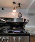 A round-bottom wok on a gas stove using a Cast Iron Wok Ring Support For Gas Stoves 9.37 Inch Outer Diameter Stable Base.