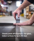Person applying Extra Heavy Duty Duct Tape 6969, Silver, Industrial Strength on warehouse floor.