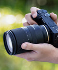 Person holding camera with 17-70mm F2.8 Di III A VC RXD Lens For Sony E APS-C Mirrorless Cameras, outdoors