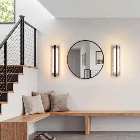 ElilyGiA 16 Inch Modern LED Wall Sconce Vanity Light, Black mounted beside a round mirror in a stylish entryway.