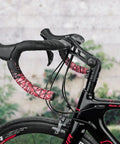 Close-up of 130 Degree Adjustable Dialed In Bicycle Stem with 31.8mm handlebars and pink tape on a black road bike.