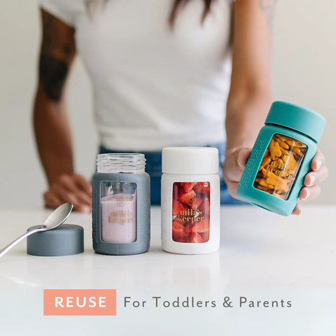 Ultra Wide Neck Glass Breast Milk Storage Bottles For Pumping And Feeding Bpa Free Silicone Caps Fit Most Pumps Aspen White Pair For Busy Mommas Keeping Fresh Stashes On Deck displayed on a table with a spoon.
