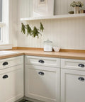 Matte Black Cup Pulls Set of 10 for Cabinets and Drawers Three and Eleven Sixteenths Inch Length installed on white kitchen cabinets