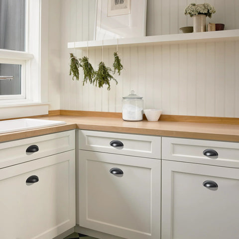 Matte Black Cup Pulls Set of 10 for Cabinets and Drawers Three and Eleven Sixteenths Inch Length installed on white kitchen cabinets