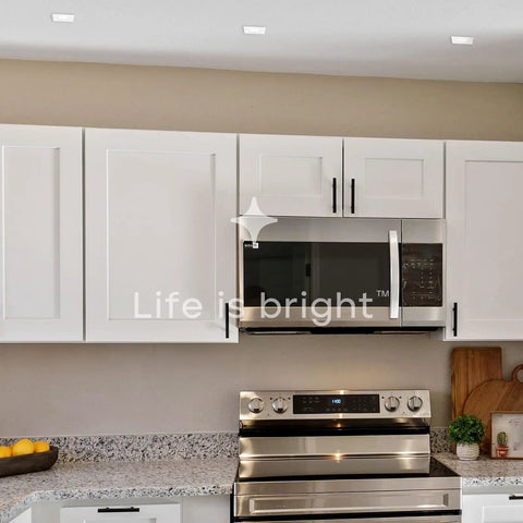 Real Deal 4 Inch Canless Recessed LED Lights Featuring Quick Dial 5 Cct Color And Heavy Duty Brackets For Tight Ceiling Gaps Wet Rated Square Trim Delivering Smooth Dimmable Performance In A 12 Pack illuminating a modern kitchen.