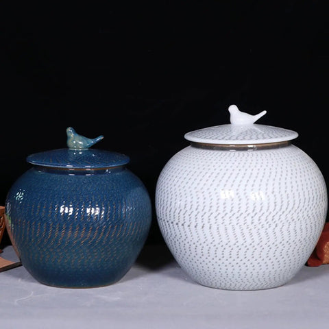 Keep Your Staples Fresh With This Heavy Duty Ceramic Rice Bucket Dispensing Grains Coffee Beans And Tea While Keeping It Tight In Your Pantry Where The Blue And White Glaze Makes Your Kitchen Setup Look Slick And Sharp. Two ceramic jars, blue and white, with bird tops for storage.