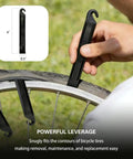 Using 16 In 1 Bike Multitool Kit For On The Go Repairs to remove a bicycle tire with a black tire lever.