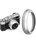 NC UV Silver Frame Lens Protector Filter For Fujifilm X100 Series Cams beside a Fujifilm camera with a silver lens