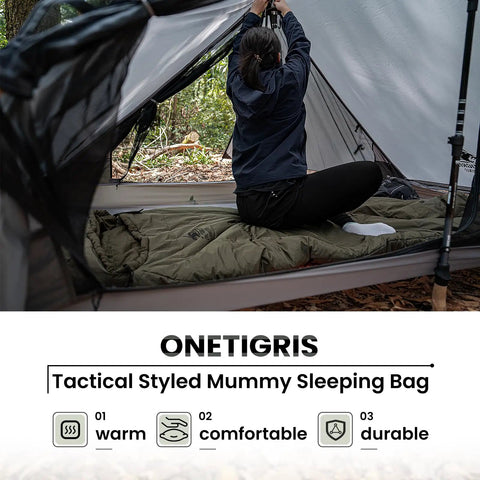Person setting up tent with 3-Season Mummy Sleeping Bag For Camping, Hiking, And Backpacking With Water-Repellent Shell in forest