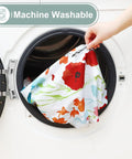 Hand placing flower print All-in-One Picnic Table Cover Set With Bench Covers For 6 Foot Tables into a washing machine.