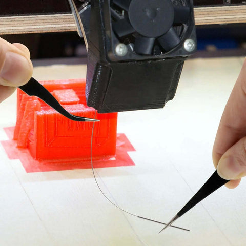 Using Nozzle Cleaning Kit For 3D Printers With Brush And Pro Tools to clean nozzle on 3D printer, demonstrating tool efficiency.