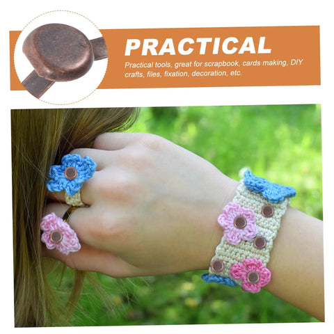 Hand wearing crochet accessories secured with 50 Pack Miniature Metal Fasteners and Close Pins for Scrapbooking Card Making and Craft DIY Brads Paper Fasteners for Arts and Crafts Projects and Creative Kid Friendly Activities Easy to Use.