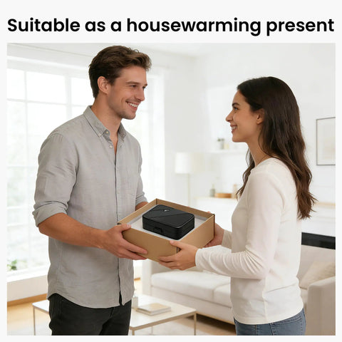Man and woman exchanging a gift box in a living room, suitable as a housewarming present, with a small appliance inside.