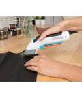 Black And Decker 4V Max Cordless Electric Fabric Craft Scissors With Usb Rechargeable Battery cutting black leather on wood surface.