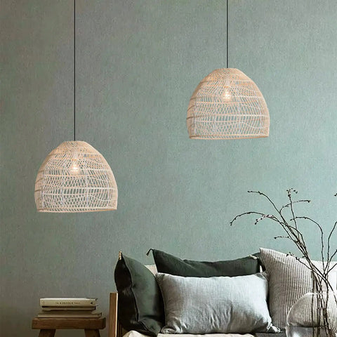 Two Pack Woven Rattan Pendant Lights for Kitchen Island and Living Room hanging above a cozy sofa setup, emitting soft ambient light.