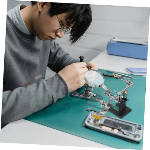 Person using Pro Grade Repair Clip Magnifying Mirror and PCB Holder for Soldering Station, electronics repair setup.