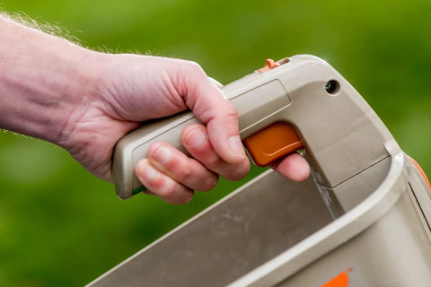 Person holding No Crank One Touch Battery Powered Spreader For Fertilizer Seed And Ice Handheld Spreader With EdgeGuard Tech
