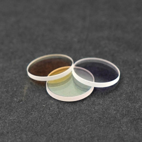 Three Universal 20mm Laser Protective Lens 3mm Thick for 1000 to 3000 Watt Handheld Laser Welding Machines 1064nm on a dark surface