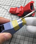Using the Rock Solid Stainless Steel Hobby Craft Ruler for precise engraving on a model part with tape.