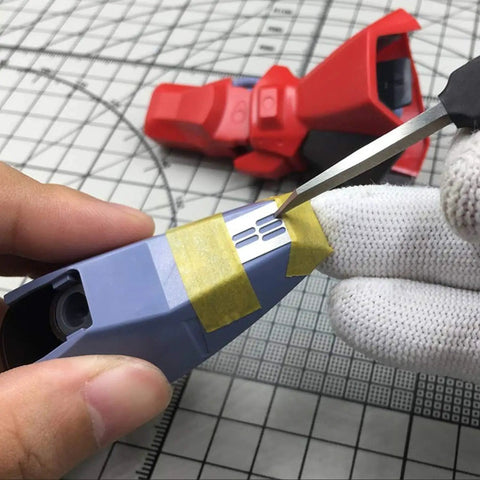 Using the Rock Solid Stainless Steel Hobby Craft Ruler for precise engraving on a model part with tape.