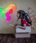 Smart Rhombus LED Wall Panels for Gaming Setup, 9 Pack RGB colorful rhythm edition illuminating a room with a child playing.
