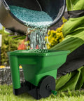 Easy Grip Hand Spreader for Lawns and Gardens, Portable Seed and Fertilizer Spreader with Anti Clump Hopper in use on grass.