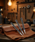 Three Piece High Carbon Steel Center Punch Set For Metal Wood And Alloy Steel 10cm Long Includes One Quarter Inch Three Eighth Inch And One Half Inch Tips placed on leather pouch in workshop.