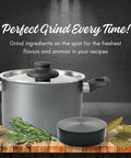 Kitchen pot with glass lid on wooden countertop; rosemary sprigs nearby