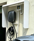 Rugged Outdoor EV Charger Cover Takes Care Of Business By Keeping Your Wall Mount Charger Dry Through Rough Weather While Offering A Waterproof Galvanized Steel Guard With Universal Fit on a wall-mounted charging station.