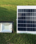 JUDYSSY Home Floodlight with a solar panel and LED spotlight on grass, 50W outdoor waterproof design.
