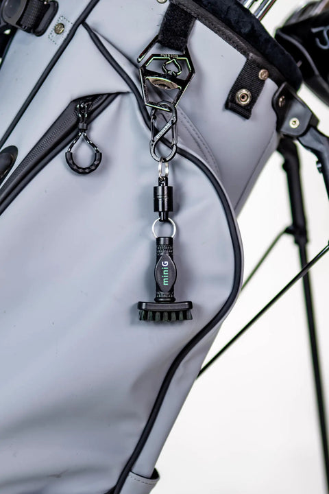 Mini Golf Brush with Detachable Magnet and Heavy Duty Nylon Bristles clipped to golf bag for quick club cleaning on the go