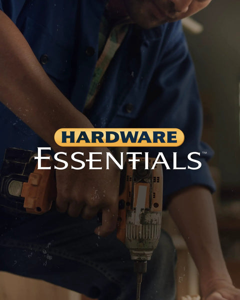 Person using a drill while wearing a blue shirt, demonstrating hardware essentials in home improvement.